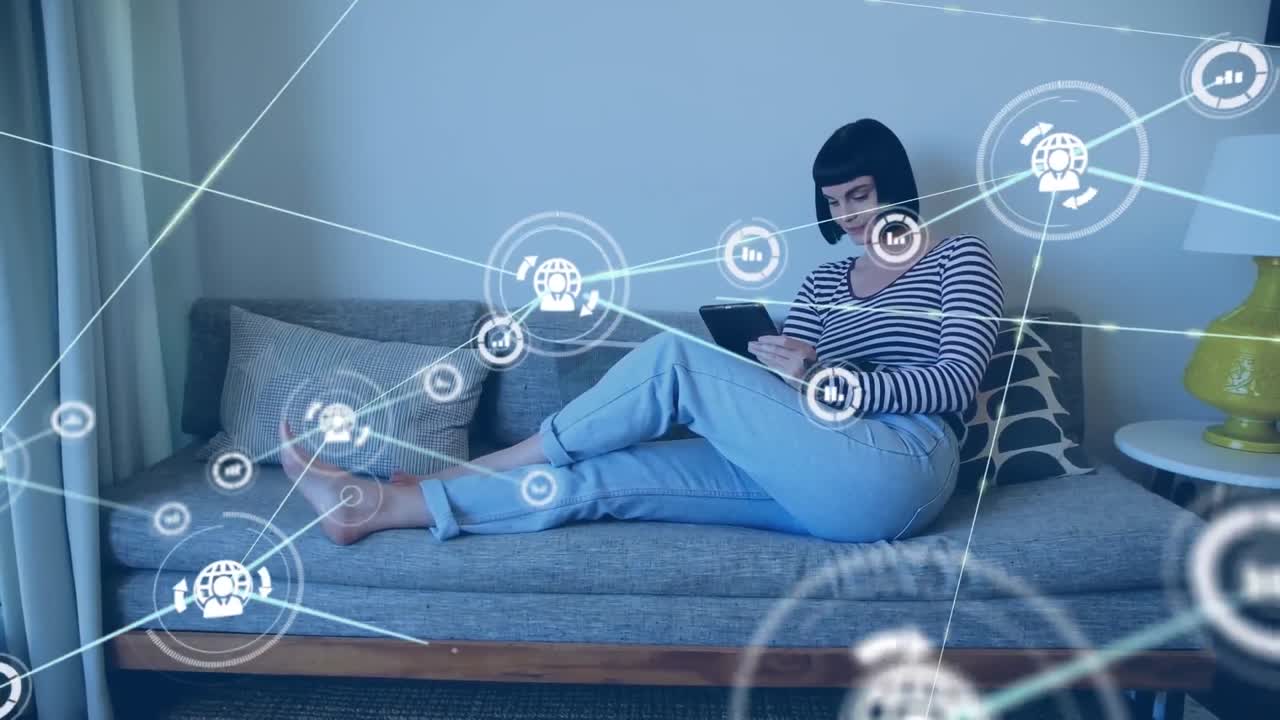 Animation of network of digital icons against happy caucasian woman using tablet on couch at home