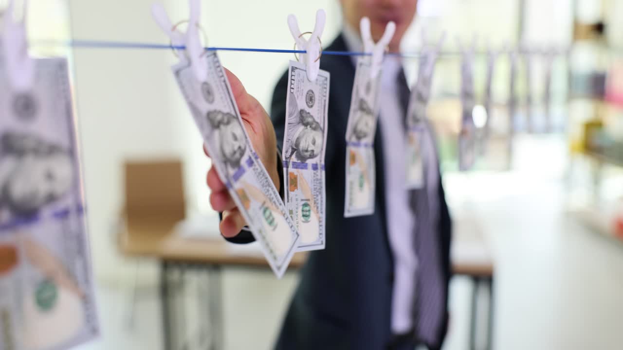 One hundred dollar bills hanging on a clothesline, representing money laundering