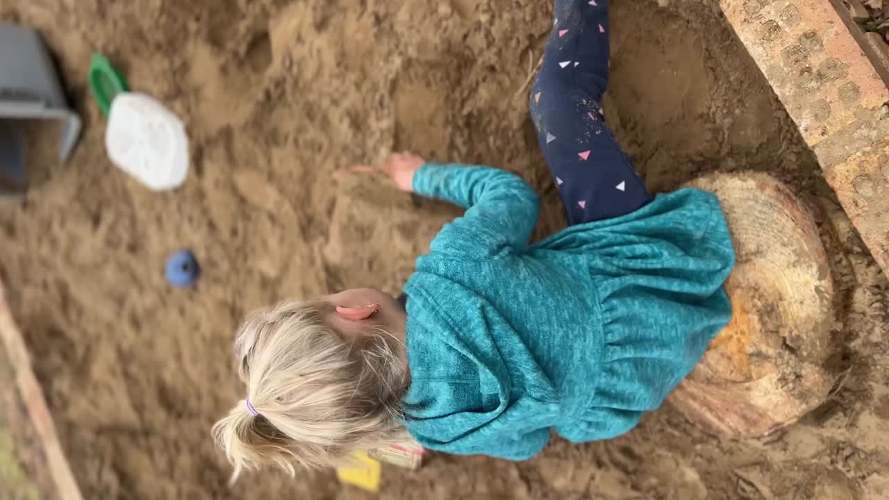 Little Girl Playing in a Sandbox