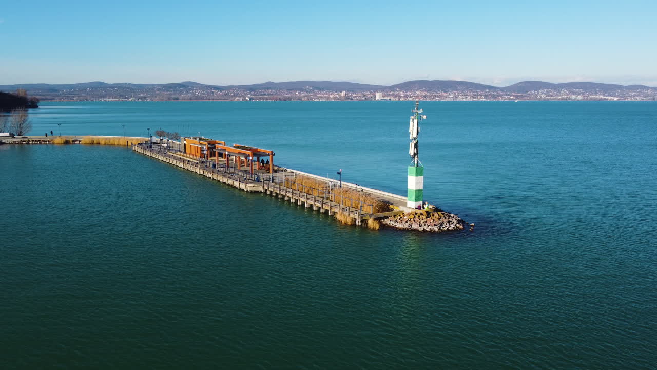 Drone view of ferry pier at Hajokikoto, Lake Balaton on a sunny day with boats and waiting area