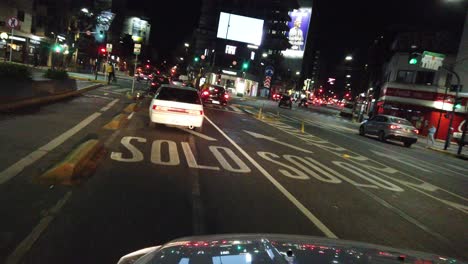 nighttime drive through palermo: pov view of cordoba avenue traffic lights in buenos aires