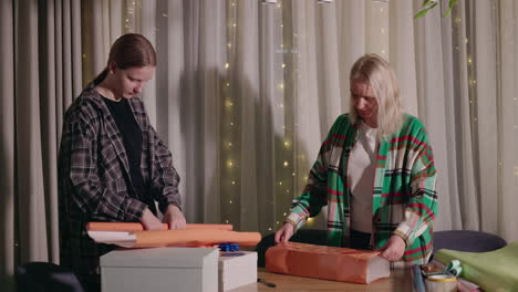 mother and daughter wrapping gifts together