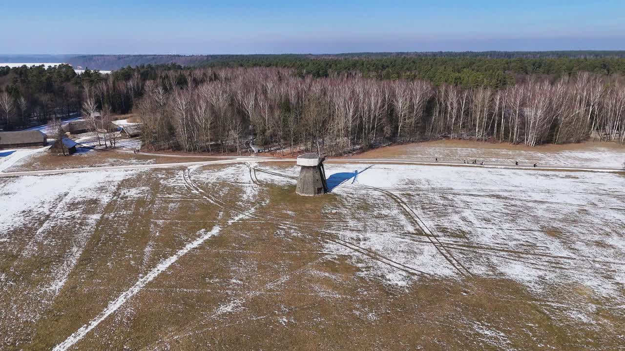 Old wooden millhouse near village and forest, aerial orbit view