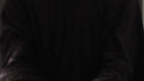 manos orando en fondo negro con espacio para copiar