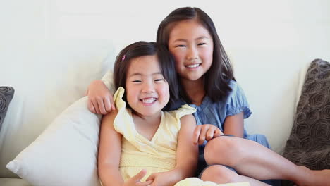 girl hugging her sister as they sit together