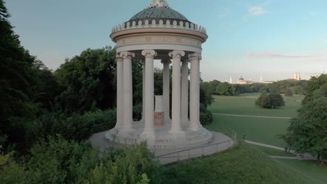 drone flying through the monument in english garden in munich germany - monopteros