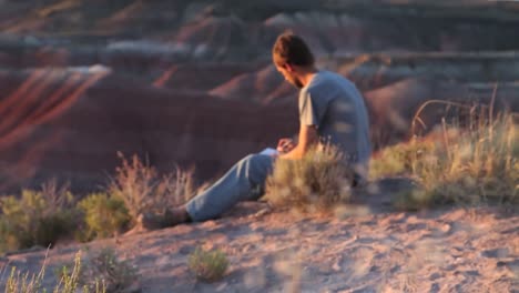 un hombre escribe en su diario en el desierto