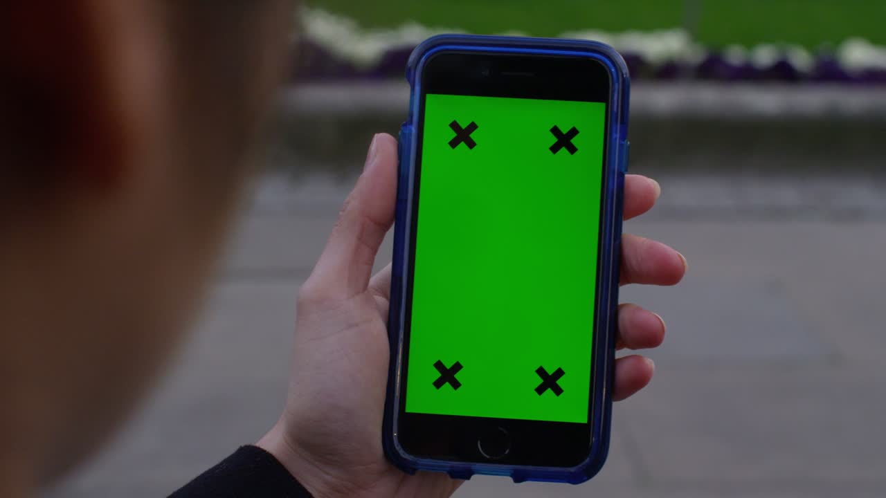 pantalla verde de la llave de croma del teléfono celular con la mano