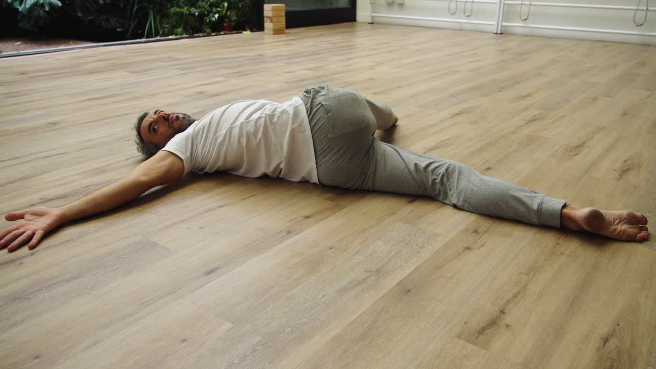Man Lying on Floor in Relaxation Pose After Yoga Practice