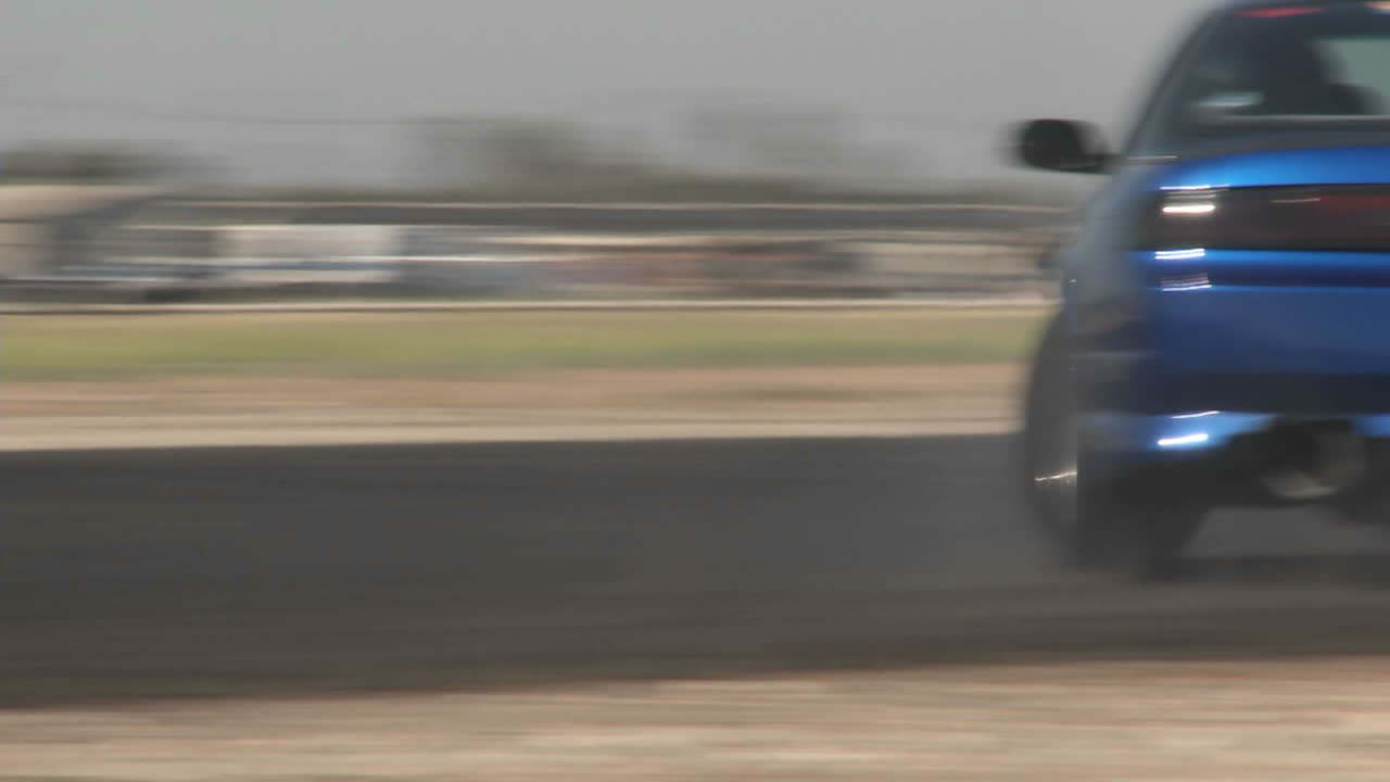 la cámara sigue un automóvil azul mientras se desliza a través de un curso a la deriva en el aeropuerto de camarillo en camarillo california