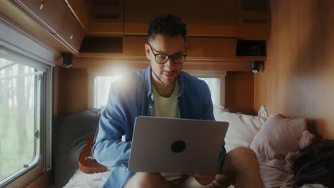 hombre trabajando en una computadora portátil en una caravana