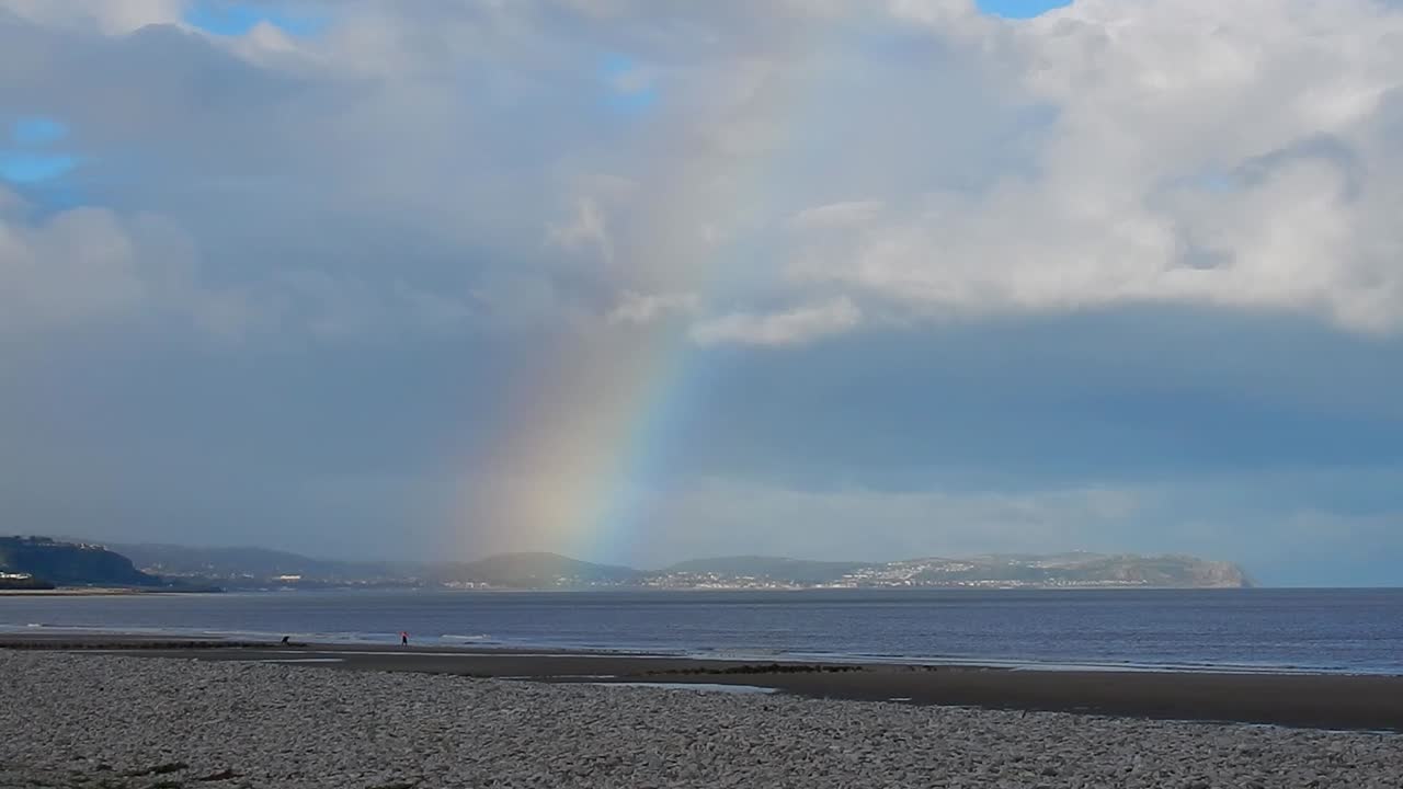 arco iris colorido escénico sobre el horizonte de la costa de las montañas galesas