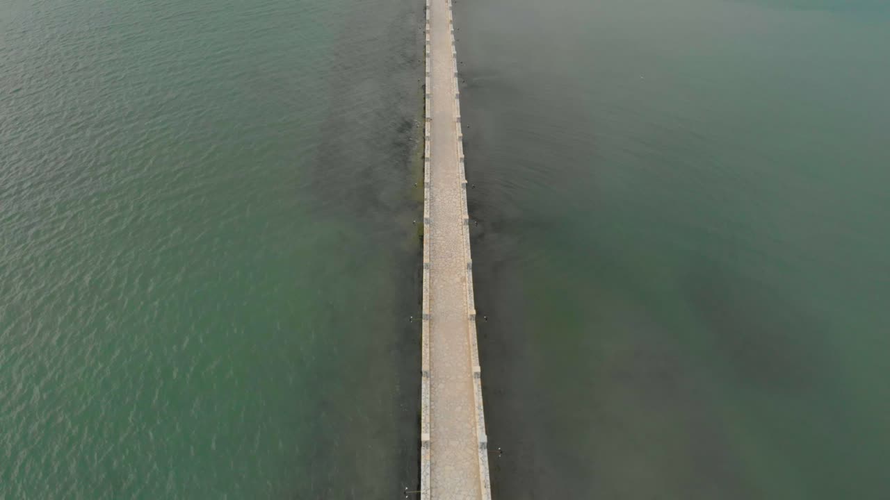 작은 그리스 이국적인 섬인 koukoumitsa vonitsa 그리스에 도착하는 교량 도로에서 흰색 밴 패스를 따라가는 공중 드론 영상