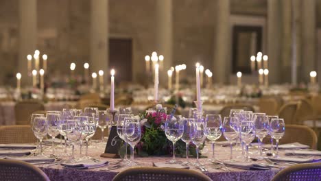 elegant wedding reception table with floral centerpiece, candles, and glassware