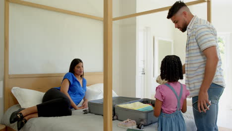 family packing suitcase on bed, preparing for vacation with excitement and smiles