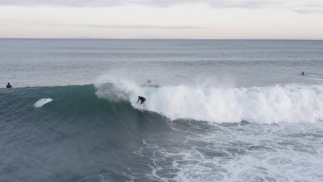 Surfista-De-Invierno-Se-Levanta-Y-Monta-Olas-En-El-Frío-Mar-De-Islandia,-Aéreo