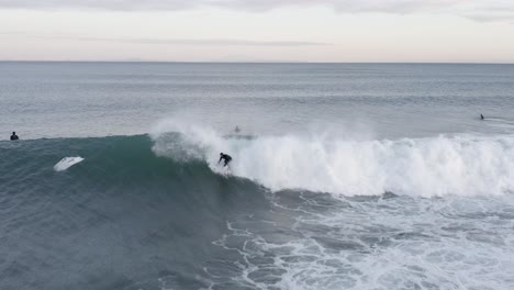 surfista de invierno se levanta y monta olas en el frío mar de islandia, aéreo