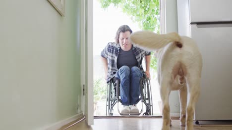 happy caucasian disabled man in wheelchair entering his house with his dog