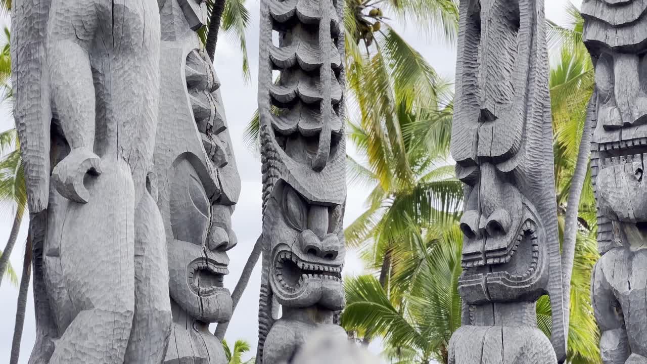 Cinematic close-up booming up shot of the tiki statues on the royal grounds of Pu'uhonua O Honaunau in Hawai'i
