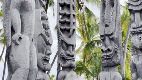 Cinematic close-up booming up shot of the tiki statues on the royal grounds of Pu&#039;uhonua O Honaunau in Hawai&#039;i
