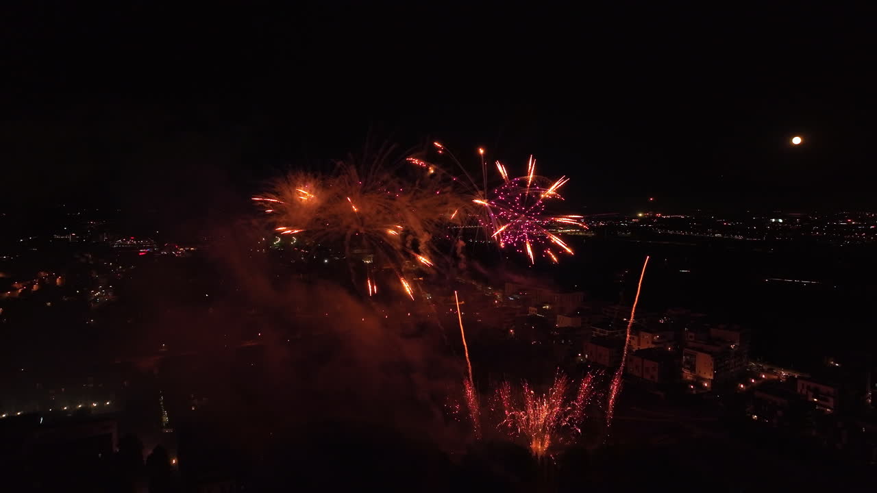 una foto aérea de montpellier bañada en el resplandor de un espectacular espectáculo de fuegos artificiales.