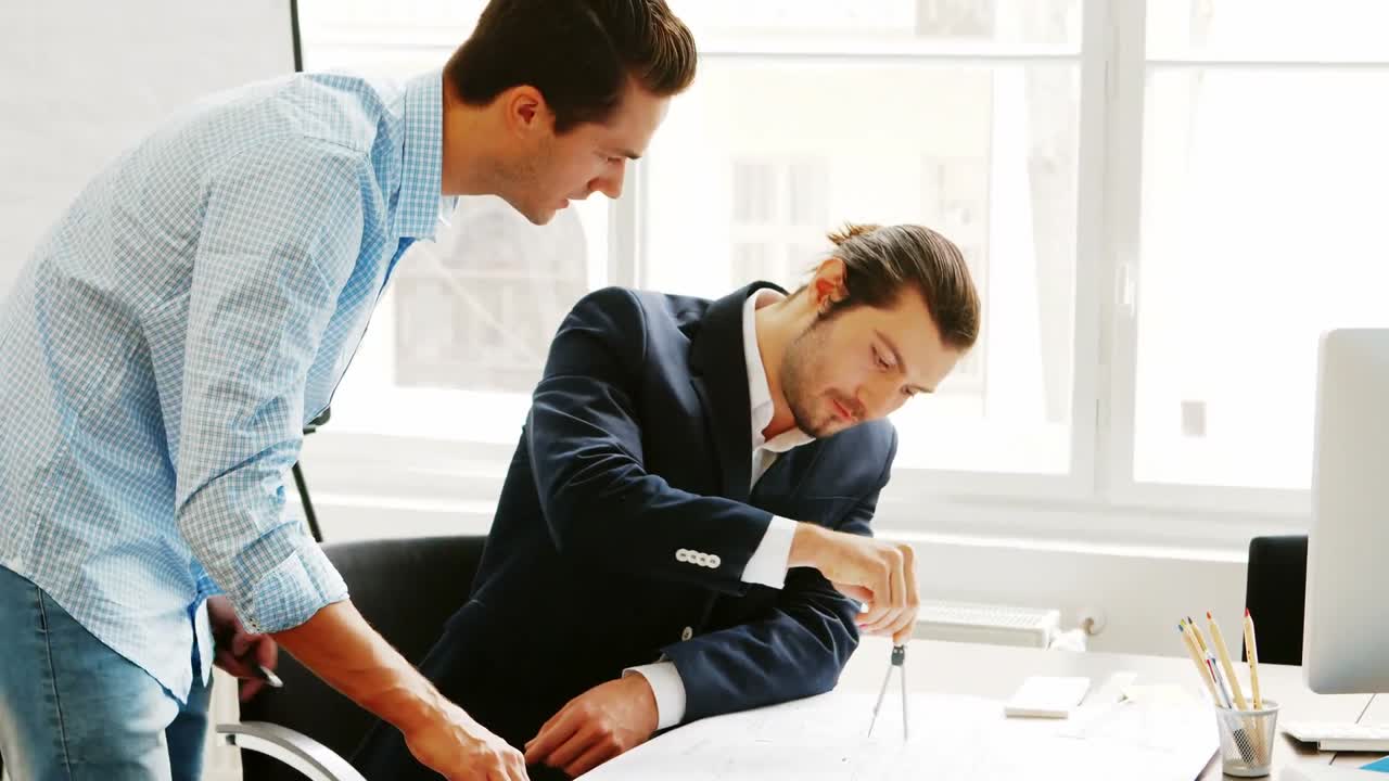 비즈니스 동료들이 청사진에 대해 논의하고 있습니다.