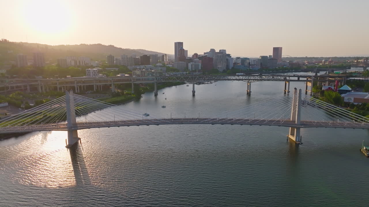 Beautiful twilight aerial of Portland, Oregon's Willamette River and bridges. Wide shot, camera flies backward.