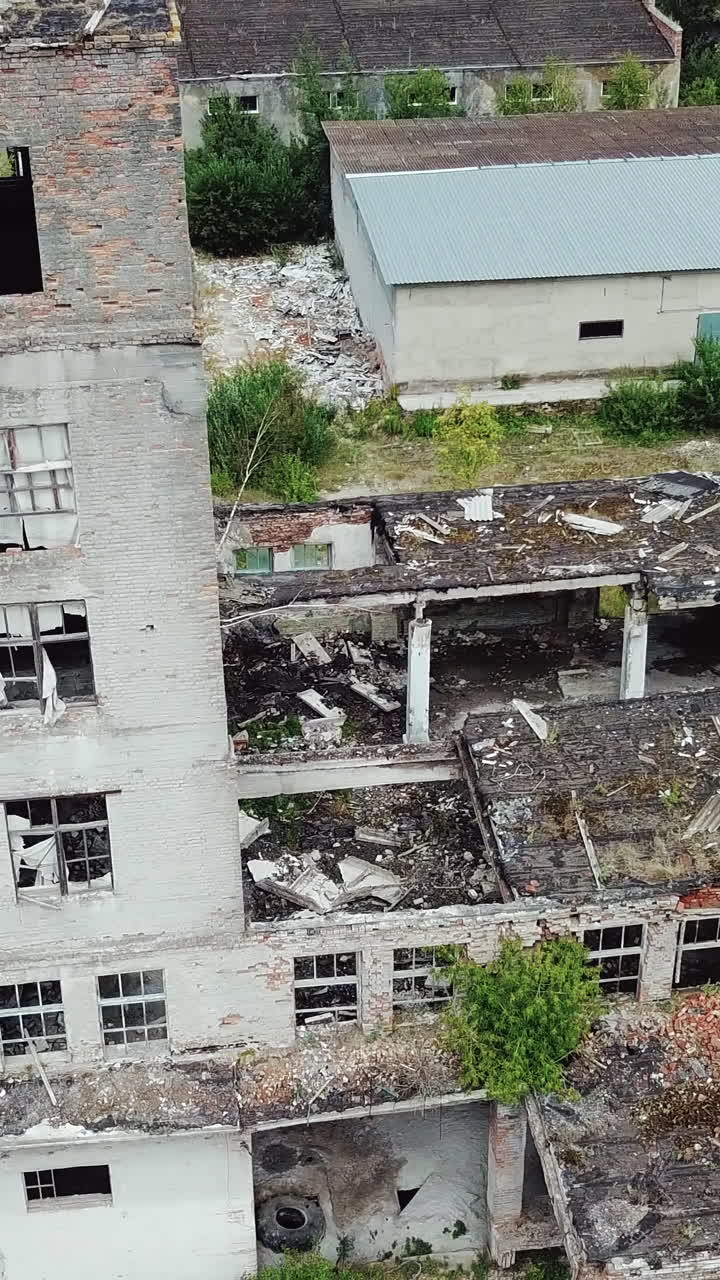 Ruins of an old factory. Old industrial building for demolition. Aerial view. Vertical video