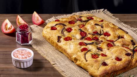 Traditional-Italian-Focaccia-with-pepperoni,-cherry-tomatoes,-black-olives,-rosemary-ando-onion---homemade-flat-bread-focaccia