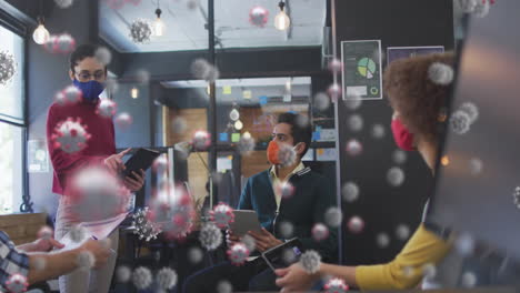 animation of covid 19 cells over colleagues in office wearing face masks