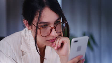 mujer triste con gafas navegando por las redes sociales