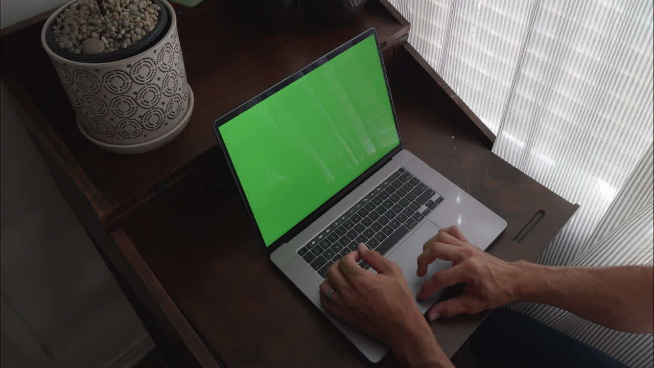 Scrivania da ufficio domestico con un uomo che lavora al laptop