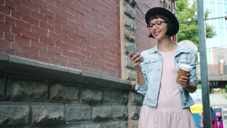 stylish woman walking down the street with coffee and phone
