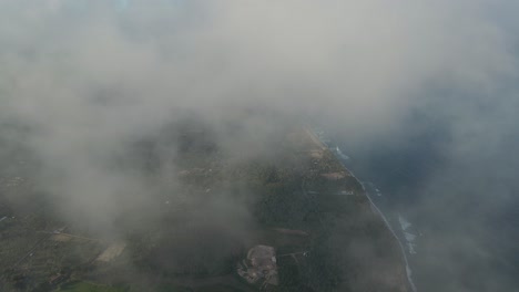 Beautiful-Aerial-Cinematic-Drone-Shot-Flying-Through-Mist-High-Up-Above-a-Coastal-Island