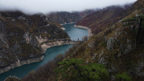 aerial drone shot over the pivsko lake situated in the mountain valley in montenegro on a cloudy day