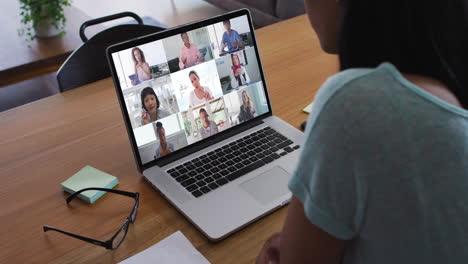 african american woman having a video conference with office colleague on laptop