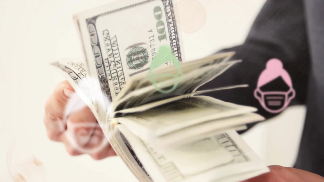 Animation of woman wearing face mask icons over mid section of businessman with dollar bills