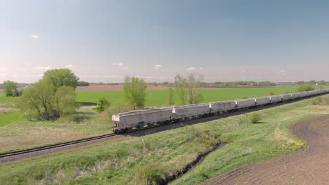 freight train rolling through rural farmland