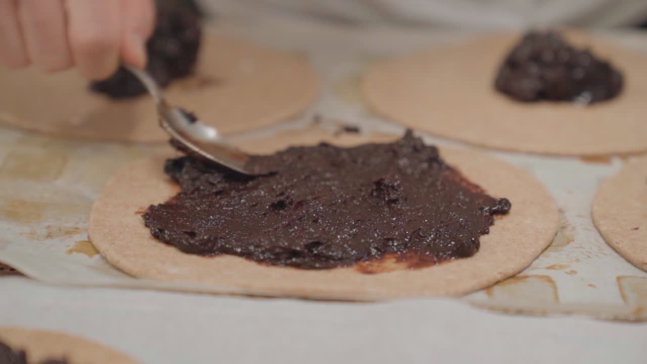 esparciendo mermelada de ciruela en la galeta con cuchara