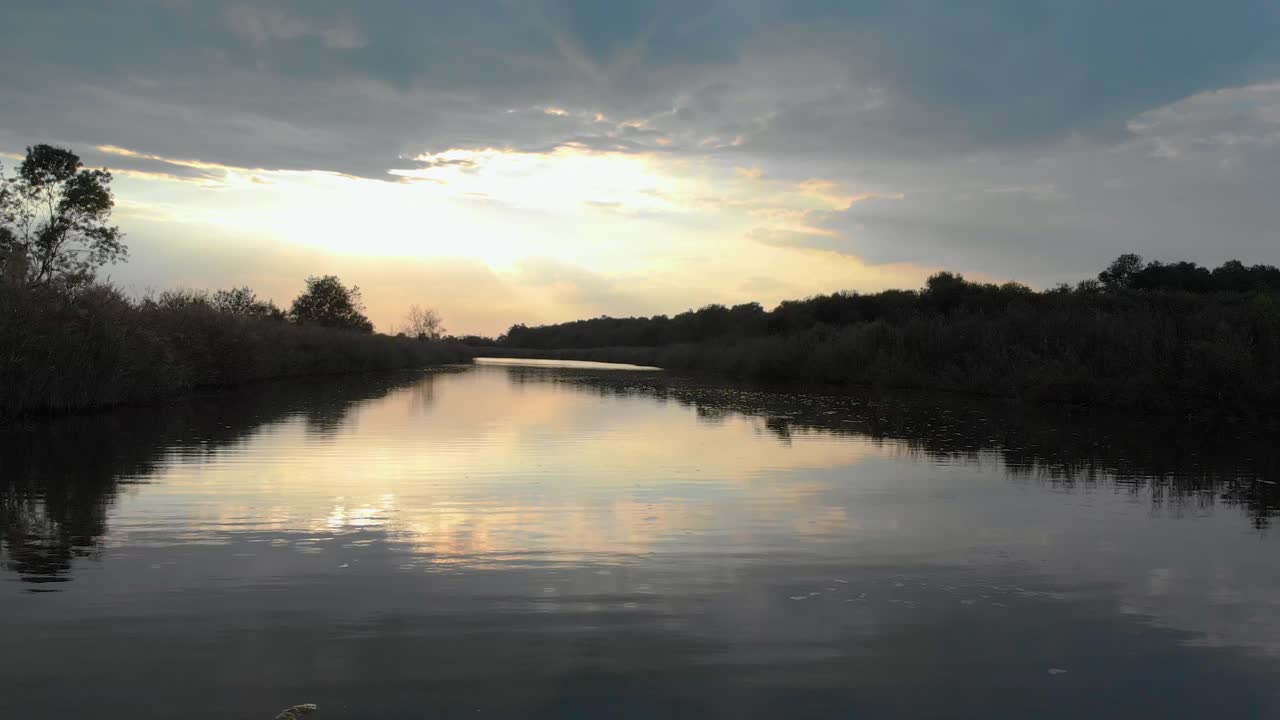 강에 가까운 낮은 드론 샷은 가벼운 비에서 상류로 날아갑니다.