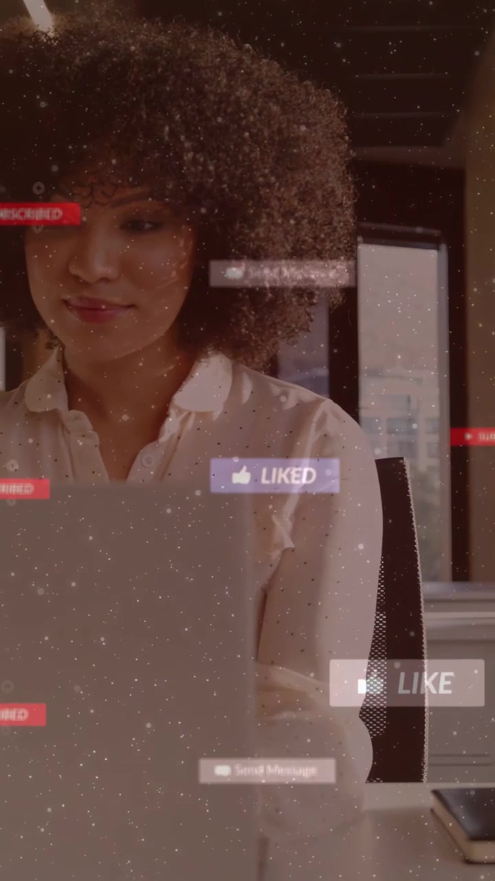 Vertical video: Woman typing on laptop clicking LIKE causing floating alerts boosting social reach