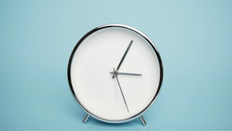 silver wall clock on a blue background.