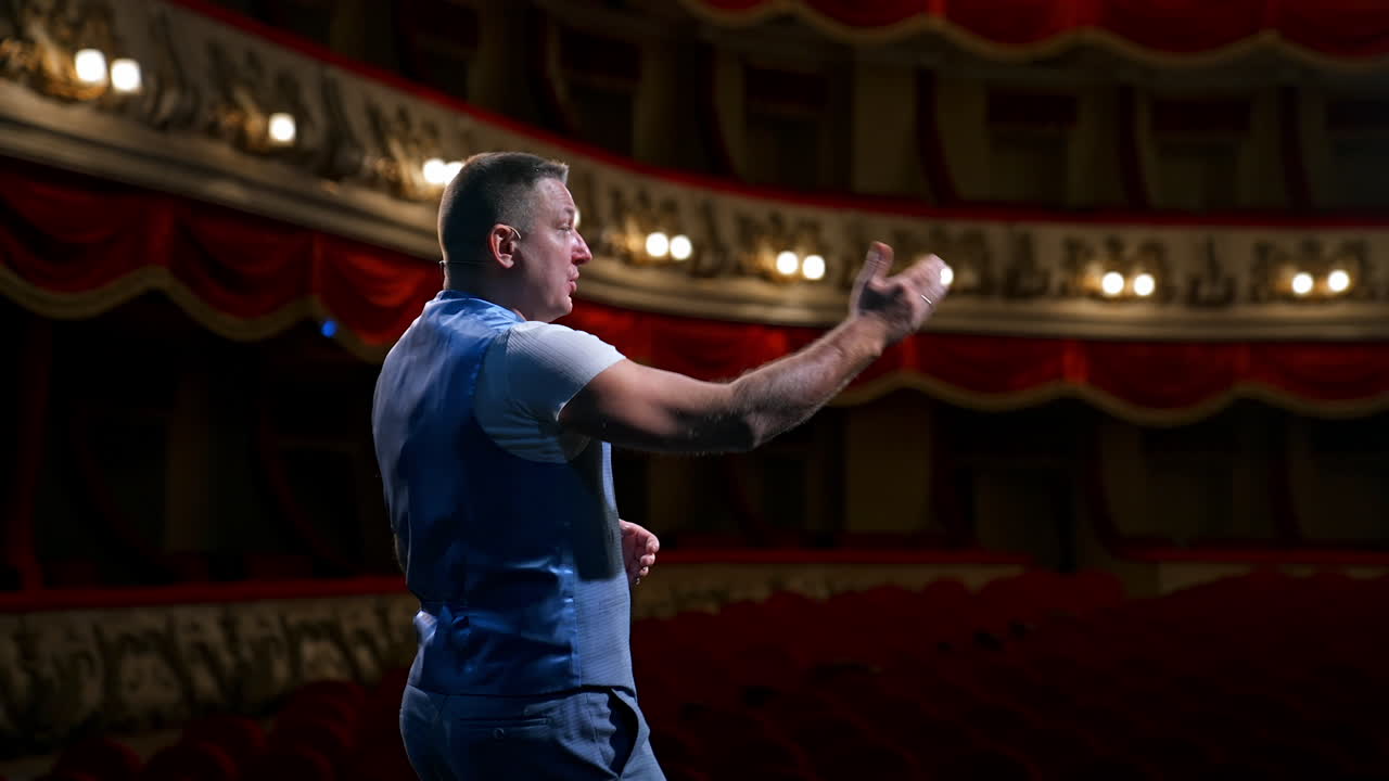 Rehearsal in the theater. Male actor talking from stage to the empty audience during quarantine. Pandemic concept.