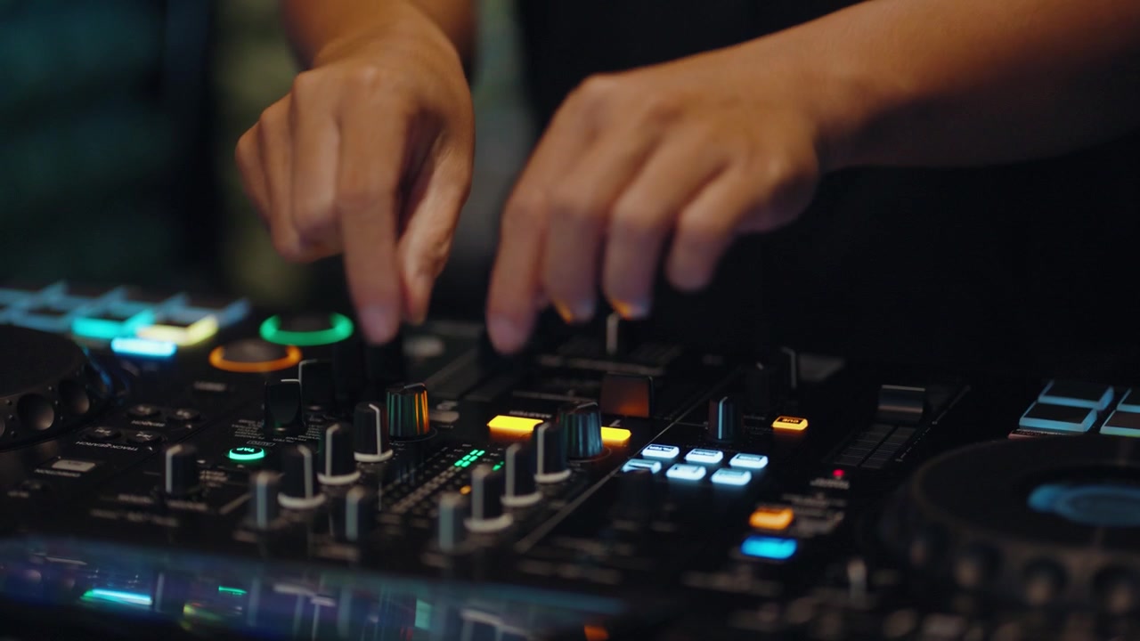 DJ che regola manopole e fader su una console di missaggio audio professionale.