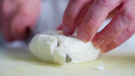 chef cortando queso feta en la cocina