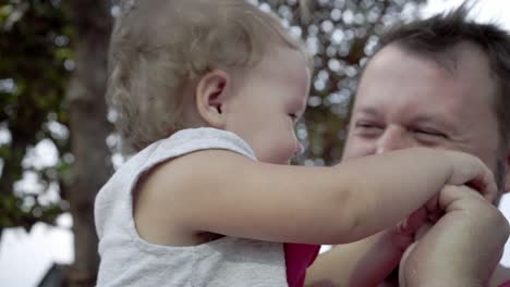 closeup of father and daughter playing together. the young father rotates the daughter in his hands, laugh, play. the concept of a happy family