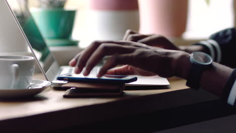 person working on laptop and smartphone