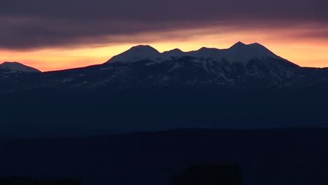 longshot of the la sal mountains silhouetted against a golden sky