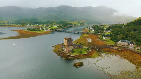 overcast sunrise over the loch at eilean donan castle in scotland, 4k aerial pan around castle in the scottish highlands