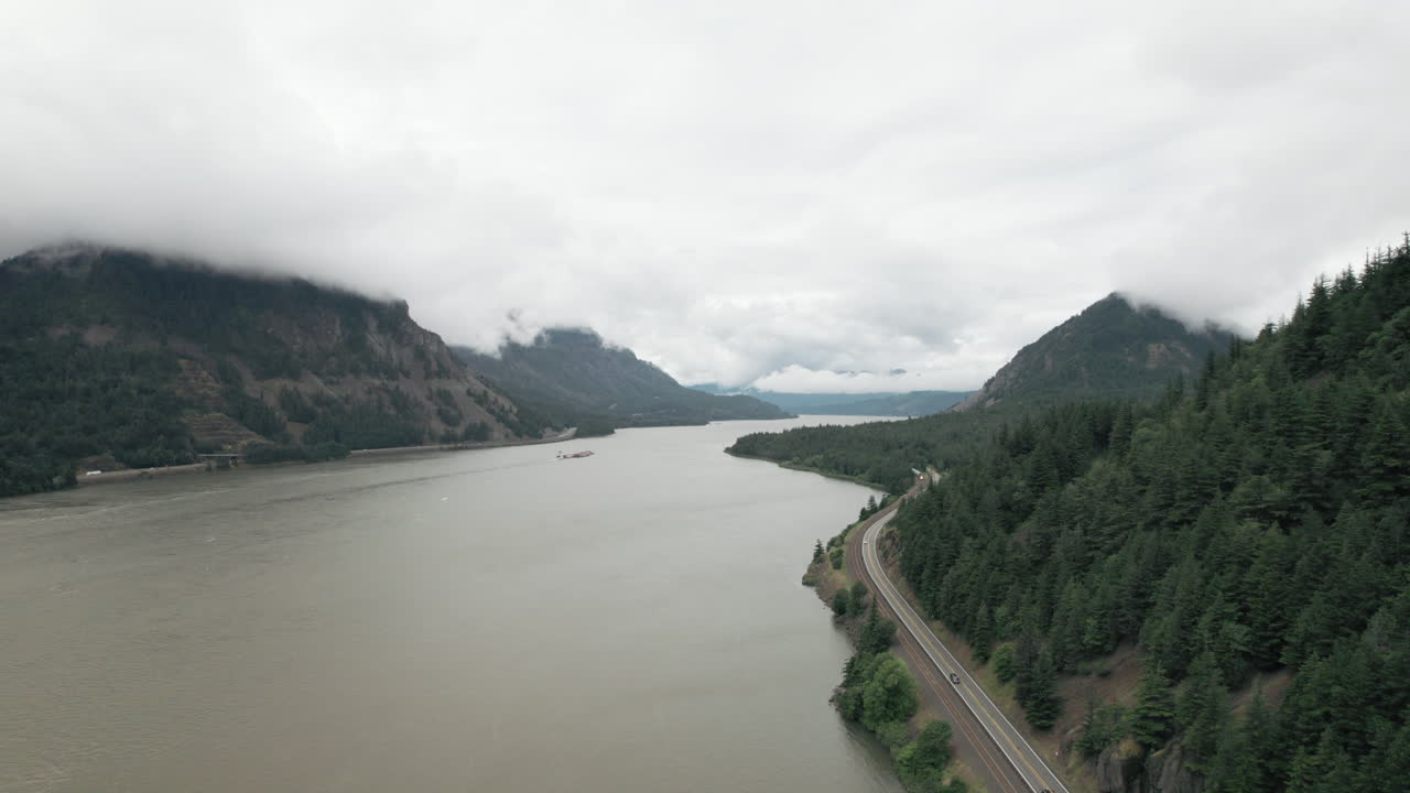 Aerial rise above Columbia River separating Washington State and Oregon. Traffic on highway.